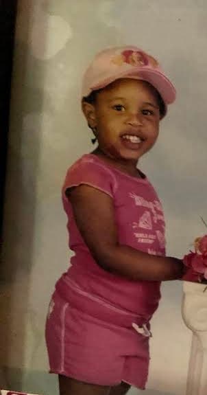 Shayna Vincent as a young child wearing pink